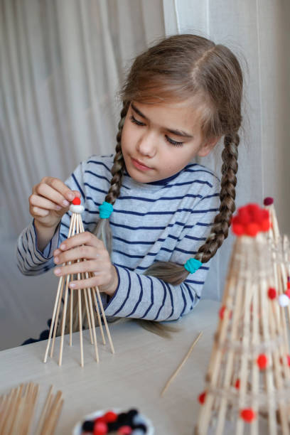 istock Kids make crafted Christmas tree from bamboo sticks, reusable ornament, DIY New Year decoration 1346713191