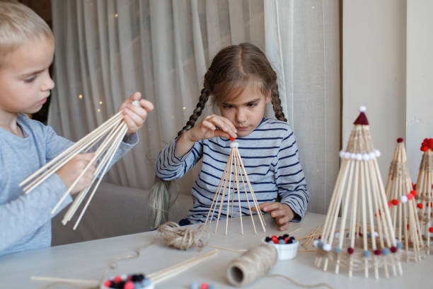istock Kids make crafted Christmas tree from bamboo sticks, reusable ornament, DIY New Year decoration 1346713204