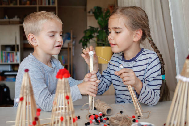 istock Kids make crafted Christmas tree from bamboo sticks, reusable ornament, DIY New Year decoration 1346713295