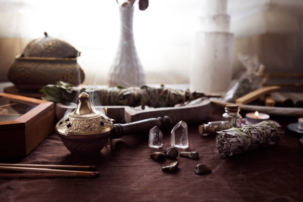 Altar for energetic cleansing and witch rituals with various bundles, stones and crystals Altar for energetic cleansing and witch rituals with various bundles, stones and crystals and a medicinal herb burner with smoke coming out crystal altar stock pictures, royalty-free photos & images