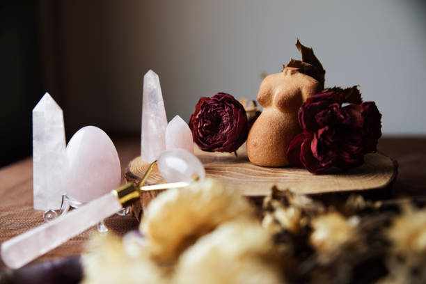 natura morta con una figura di argilla di una donna incinta decorata con rose secche e vari cristalli di quarzo rosa - spirit medium foto e immagini stock