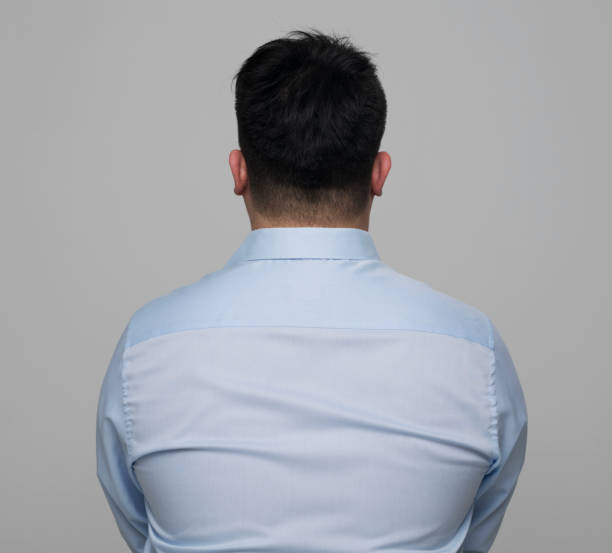 Rear view of young man wearing light blue shirt