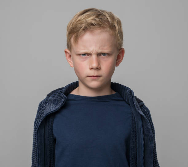istock Close-up of angry boy wearing blue jacket 1346716749
