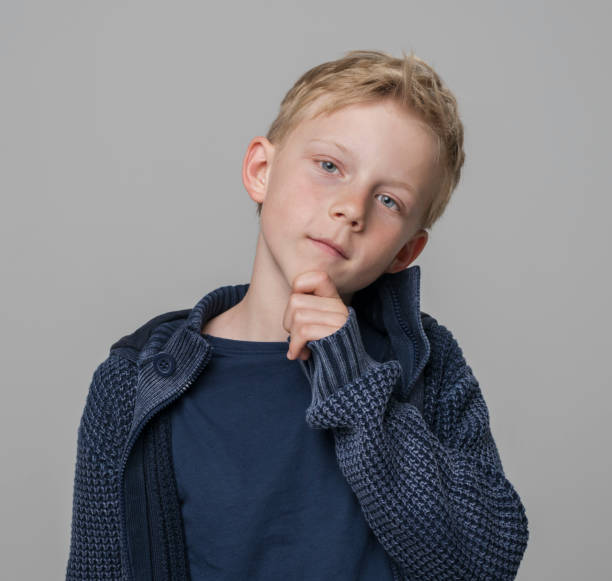 istock Close-up of thoughtful boy with hand on chin 1346716767