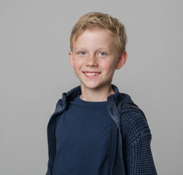 istock Smiling boy standing with arms crossed 1346716772