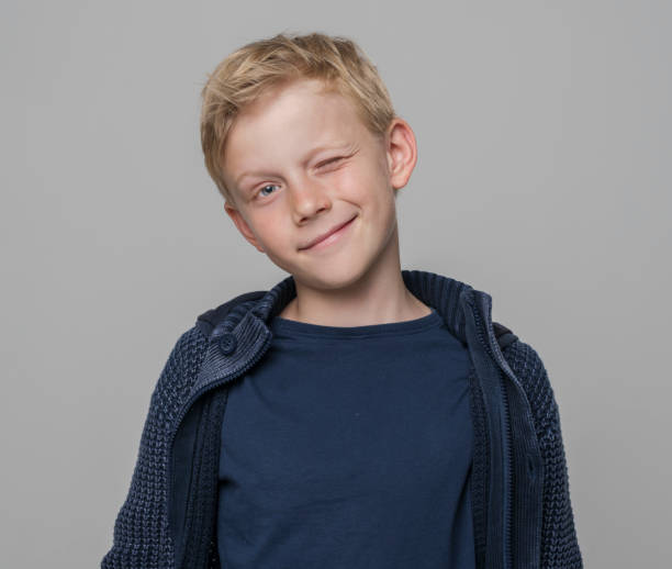 istock Close-up of smiling boy winking eye 1346716784