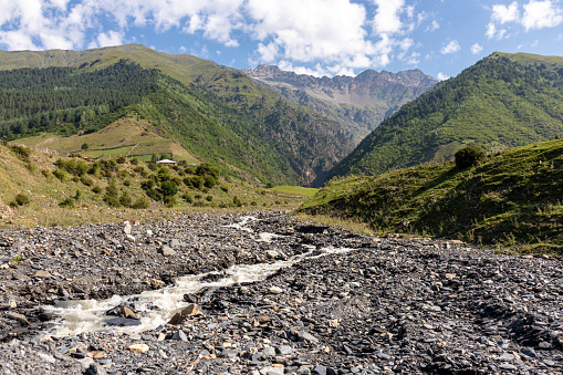 Adishi - Un torrente apresurado que baja a través de un banco pedregoso en el Cáucaso, Georgia. Hay cadenas montañosas altas alrededor photo
