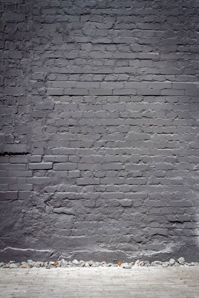 istock Old brick wall painted in black 1346718223