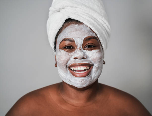 Young african girl wearing beauty skin mask treatment - Focus on face stock photo