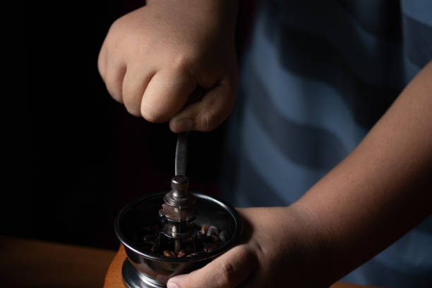 istock Hand spinning the coffee bean grinder grind enough coffee. 1346718969