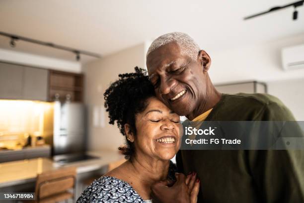 Senior couple embracing each other at home