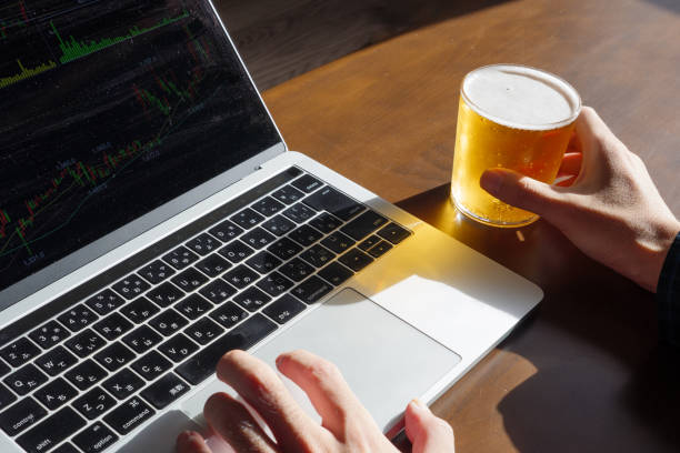 Work on a computer by remote work while drinking beer stock photo