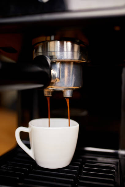 istock Detail of a professional coffe maker dripping coffe into an empty cup in a cafeteria, Machine is making a perfect coffee with delicious smell, . Espresso Coffee Machine Making Espresso Coffee 1346721629