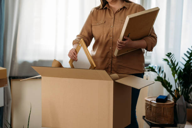istock Moving out: Anonymous Overweight Woman Packing Picture Frames 1346727139