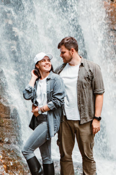 istock couple hikers tourists looking at waterfall 1346727991
