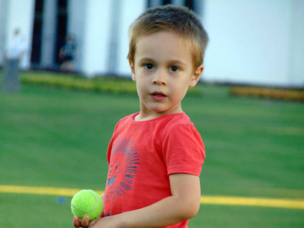 istock a little boy is playing in the grass 1346730311