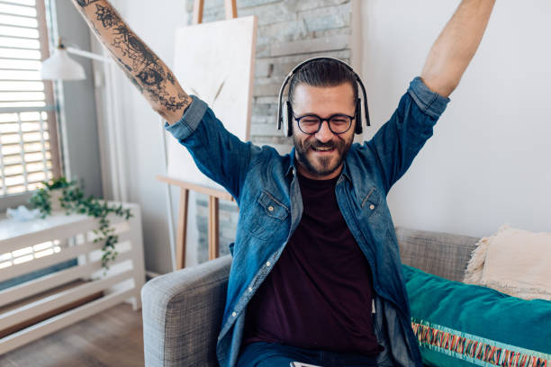 istock Happy young man enjoying music at home 1346732597