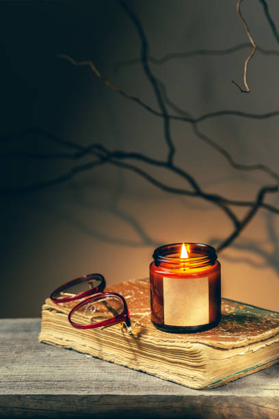 istock Reading an old book by candlelight at night 1346735468