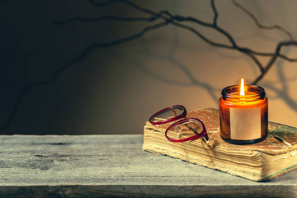 Reading an old book by candlelight at night