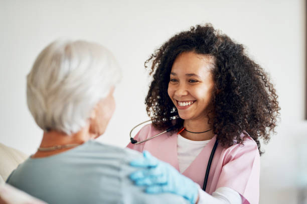 Cropped shot of an attractive young female nurse talking to her senior patient while sitting in the retirement home stock photo