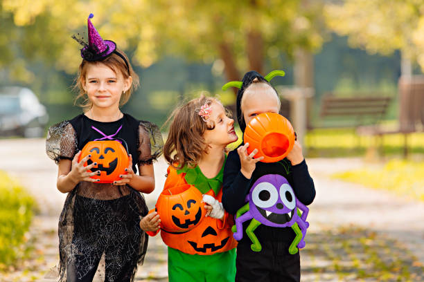 istock Happy Halloween. three running kids with a basket for sweets 1346739576