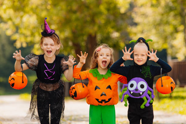 istock Happy Halloween. three running kids with a basket for sweets 1346739578