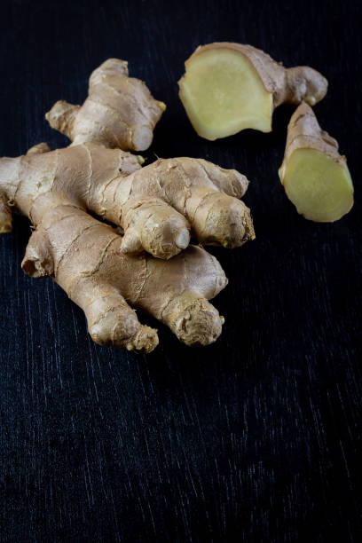 istock Fresh ginger on black wooden background. 1346740109