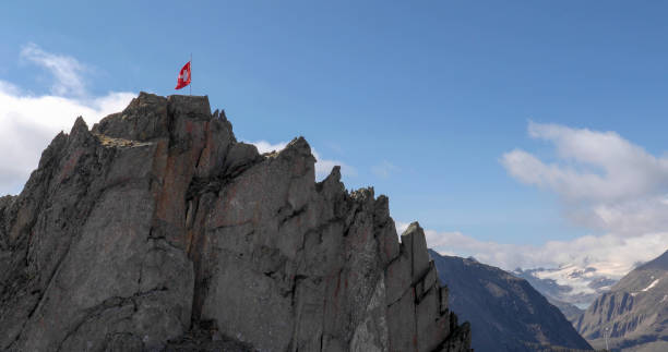 istock Swiss flag blows in the wind on a rocky summit 1346742154