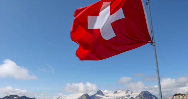 istock Swiss flag blows in the wind on a rocky summit 1346742166