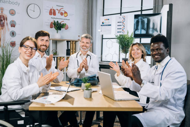 istock Multiracial doctors clapping and smiling at office room 1346745480