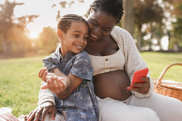 istock African mother and mixed race son using mobile phone at park 1346746889