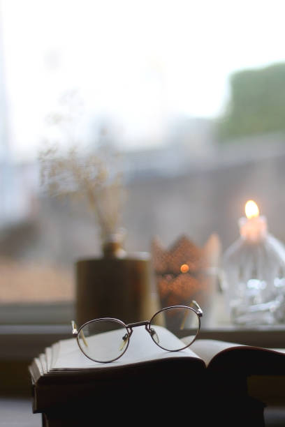 istock Book, Reading Glasses, Candles and Flowers 1346749187
