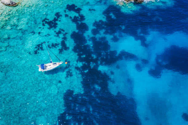 Aerial view of lonely yacht boat in secluded remote beach on the Ionian island of Kefalonia, Greece Aerial top down view to the beautiful and secluded Fteri beach on the Ionian island of Kefalonia, Greece ithaca stock pictures, royalty-free photos & images