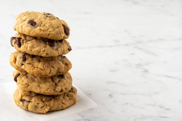 Stack of Chocolate Chip Cookies on Kitchen Counter with Copy Space Stack of chewy chocolate chip oatmeal cookies on a white kitchen counter with copy space chewy stock pictures, royalty-free photos & images