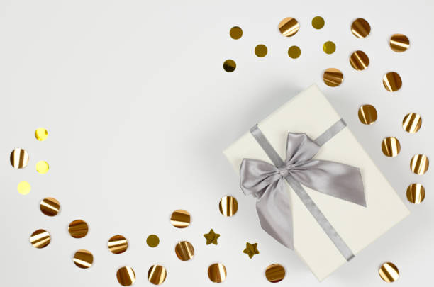 istock Invitation or postcard with place for text. White gift box with a large bow on a white background with sparkles, copy space. Festive concept 1346754922