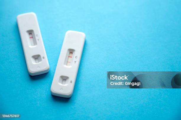 Coronavirus Antigen Rapid Tests Device With Positive And Negative Result On A Blue Background Copy Space Stock Photo - Download Image Now