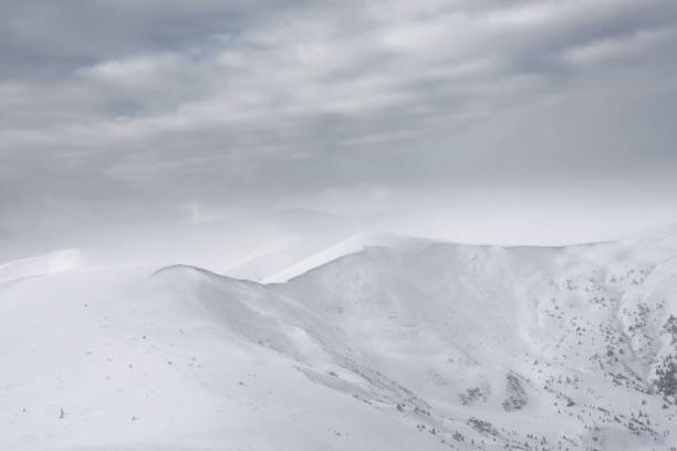 istock Snow-covered mountain range against the backdrop of a cloudy sky. 1346757742