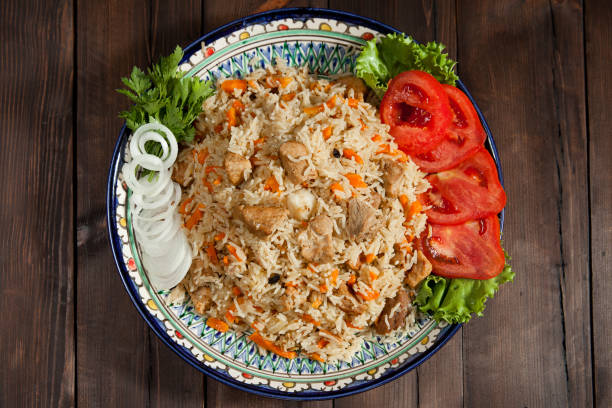 istock Pilaf with meat on a plate on a wooden table 1346758124
