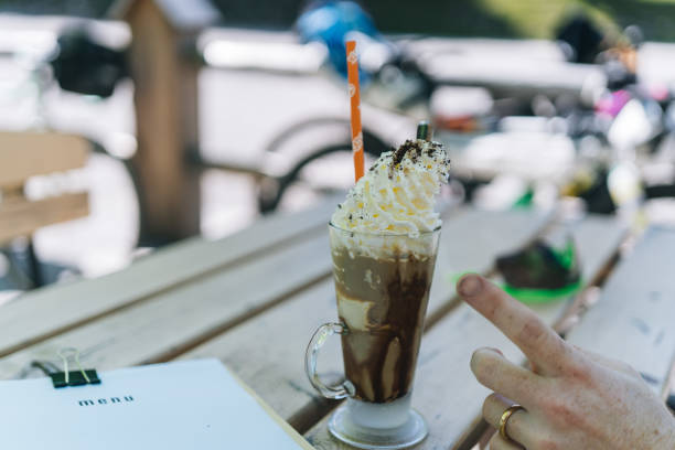 Fancy, chocolate  beverage with whipped cream and straw at an outdoor cafe
