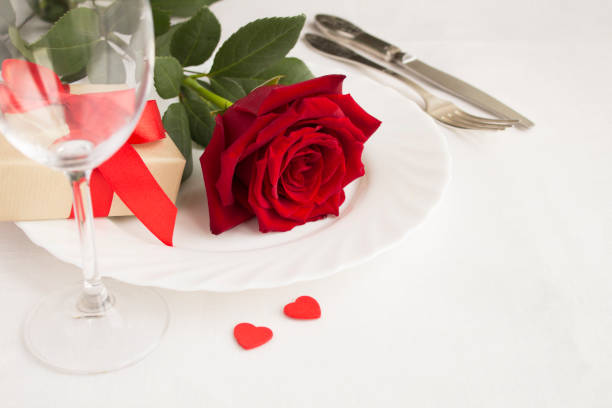 Valentine's day table setting with red rose and gift. Close-up.