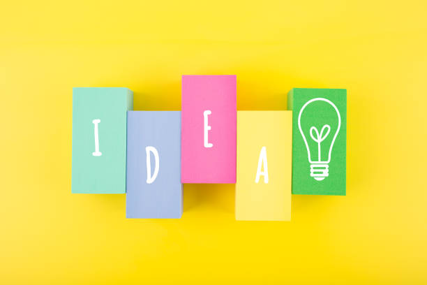 istock Creativity and idea concept. Single word idea and light bulb drawn on multicolored rectangles on yellow background 1346764846