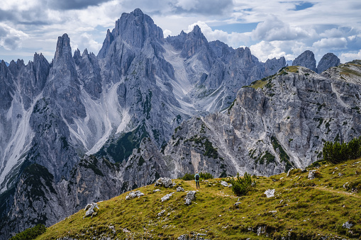 Woman hiker with backpack against Cadini di Misurina mountain group range of Italian Alps, Dolomites, Italy, Europe.