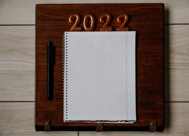 istock Notepad and pen on a dark wooden background. Planning for 2022 1346773867