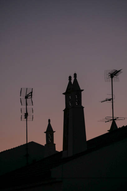 dämmerungsschornsteinsilhouette, alte antennen - television aerial roof antenna city stock-fotos und bilder