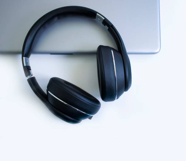istock laptop, headphones on a light background 1346777696