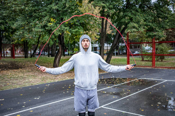 istock Young man with jumping rope on an autumn day training 1346780727