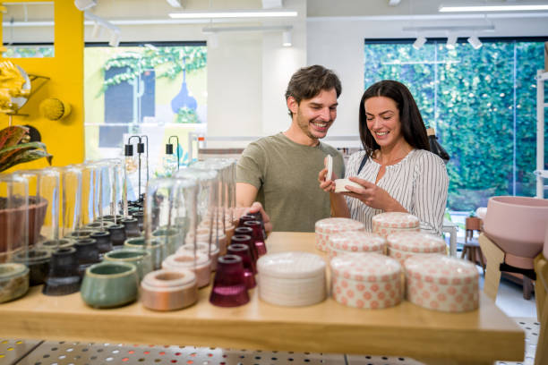 Happy Latin American couple shopping at a home decor store and looking at pottery - lifestyle concepts