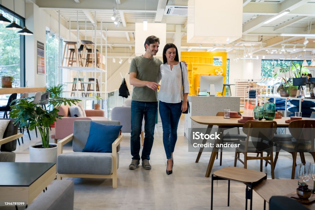 Happy couple selecting items for the wedding registry at a furniture store Happy Latin American couple selecting items for the wedding registry at a furniture store Shopping Stock Photo