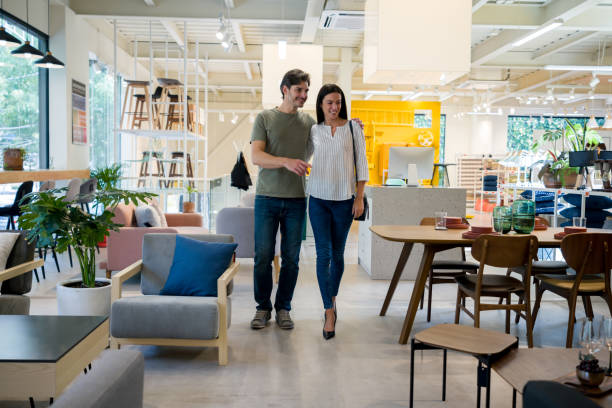 happy couple selecting items for the wedding registry at a furniture store - comprar imagens e fotografias de stock