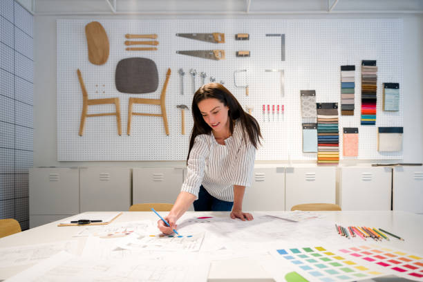 istock Interior designer looking happy coloring sketches at her office 1346781639